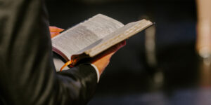 pastor payroll, pastor holding bible