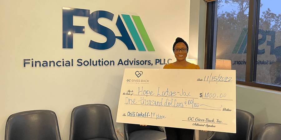 Giving Back to the Jacksonville Community - Charity winner holding check to Hope Lodge