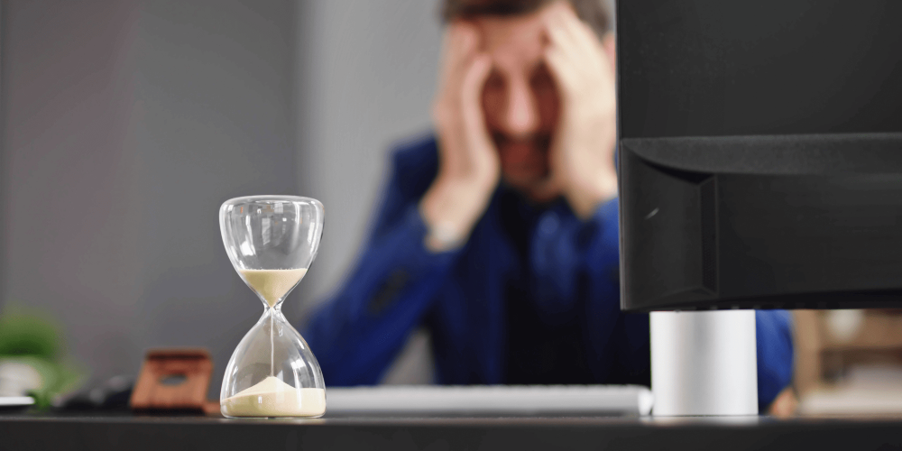 hourglass counting down in front of a man looking down